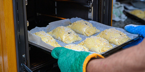 baking process with pastries topped with sesame seeds in oven ready for cooking 4 delicious pastries